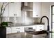 Modern kitchen with stainless steel appliances, granite countertops, and white cabinets at 1047 Banks Rose St, Kissimmee, FL 34747