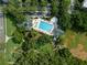 An aerial view of the community pool, playground, and surrounding green spaces within the neighborhood at 1211 Celebration Ave # 102, Celebration, FL 34747