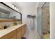Well-lit bathroom with a double sink vanity, and a walk-in shower with neutral tile at 1211 Celebration Ave # 102, Celebration, FL 34747