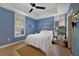 Comfortable bedroom featuring blue walls, ample natural light, and a ceiling fan, creating a relaxing ambiance at 1211 Celebration Ave # 102, Celebration, FL 34747