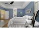 Bedroom with blue walls, ceiling fan, and white bedding, creating a cozy and inviting atmosphere at 1211 Celebration Ave # 102, Celebration, FL 34747