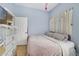 Bedroom showcasing blue walls, tiled floors, a chest of drawers, and curtains near a sunlit window, enhancing its charm at 1211 Celebration Ave # 102, Celebration, FL 34747