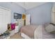 Bedroom featuring tile floors, blue walls, ample storage, and a TV, creating a cozy and functional living space at 1211 Celebration Ave # 102, Celebration, FL 34747