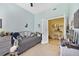 A cozy bedroom featuring light blue walls, tile floors, and an adjoining sunroom, perfect for relaxation and play at 1211 Celebration Ave # 102, Celebration, FL 34747