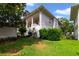 Exterior view of a multi-story building with a green lawn, mature trees, and well-maintained landscaping at 1211 Celebration Ave # 102, Celebration, FL 34747