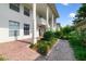 Exterior of a white building with a brick walkway, columns, and well-maintained landscaping at 1211 Celebration Ave # 102, Celebration, FL 34747