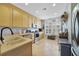 Bright kitchen featuring stainless steel appliances, light wood cabinets, tile flooring, and a large window at 1211 Celebration Ave # 102, Celebration, FL 34747