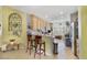 Well-lit kitchen with natural wood cabinetry and modern appliances, complemented by a stylish breakfast bar at 1211 Celebration Ave # 102, Celebration, FL 34747