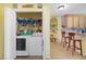 Laundry room featuring a washer and dryer inside a closet, with an adjacent kitchen/bar area with seating at 1211 Celebration Ave # 102, Celebration, FL 34747