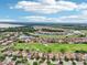 Aerial view of houses nestled around a lake and golf course, under a bright blue sky filled with fluffy clouds at 13136 Alderley Drive Dr, Orlando, FL 32832