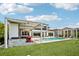 Resort-style backyard with a sparkling pool, outdoor kitchen, covered dining, and manicured lawn at 13136 Alderley Drive Dr, Orlando, FL 32832