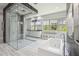 Bright bathroom showcasing a glass shower, soaking tub, and a window with natural light at 13136 Alderley Drive Dr, Orlando, FL 32832