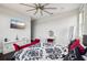 Open bedroom offers hard wood floors, a ceiling fan, a mounted TV, and bright, sunny windows at 13136 Alderley Drive Dr, Orlando, FL 32832