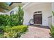 Charming home entrance with lush landscaping, a comfortable egg chair, and stylish double doors creating a welcoming ambiance at 13136 Alderley Drive Dr, Orlando, FL 32832