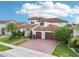 Beautiful Mediterranean-style home with a tile roof, brick driveway, manicured landscaping, and a three-car garage at 13136 Alderley Drive Dr, Orlando, FL 32832