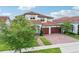 Beautiful Mediterranean-style home with a tile roof, brick driveway, lush landscaping, and a three-car garage at 13136 Alderley Drive Dr, Orlando, FL 32832