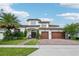 Beautiful two-story home with a three-car garage, an inviting entrance, and lush landscaping under a bright blue sky at 13136 Alderley Drive Dr, Orlando, FL 32832