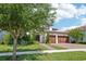 Attractive two-story home boasting a three-car garage, lush landscaping, and a brick driveway, creating a welcoming curb appeal at 13136 Alderley Drive Dr, Orlando, FL 32832