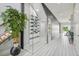 Hallway with glass wine cellar, light wood floors, and modern design elements at 13136 Alderley Drive Dr, Orlando, FL 32832