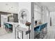 Modern kitchen with bar seating leading to a dining and living area, showcasing an open-concept design at 13136 Alderley Drive Dr, Orlando, FL 32832