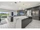 Modern kitchen featuring an island, open layout to the living area, stainless steel fridge and sleek cabinets at 13136 Alderley Drive Dr, Orlando, FL 32832