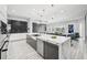 Open-concept kitchen featuring a waterfall island, modern lighting, and stainless steel appliances flowing into the living area at 13136 Alderley Drive Dr, Orlando, FL 32832