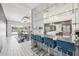Open-concept kitchen and dining area with bar seating, sleek countertops, and contemporary lighting fixtures at 13136 Alderley Drive Dr, Orlando, FL 32832