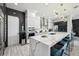Bright kitchen with waterfall island, stainless steel appliances, bar seating, and modern lighting fixtures at 13136 Alderley Drive Dr, Orlando, FL 32832