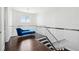 Upstairs landing with dark hardwood floors, glass railings and a blue velvet chaise lounge at 13136 Alderley Drive Dr, Orlando, FL 32832