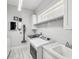 Well-lit laundry room with modern appliances, a sink, cabinetry and a mounted vacuum unit at 13136 Alderley Drive Dr, Orlando, FL 32832