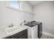 Functional laundry room equipped with modern washer and dryer, sink, and ample counter space at 13136 Alderley Drive Dr, Orlando, FL 32832