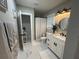 Bathroom featuring marble floors, a walk-in shower, a white vanity with a black faucet, and warm lighting at 1407 Noble Pl, Orlando, FL 32801