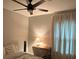 Cozy bedroom with a ceiling fan, warm lighting, and a small desk area by the window at 1407 Noble Pl, Orlando, FL 32801