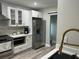 Well-lit kitchen featuring white cabinets, hardwood floors, stainless steel appliances, and ample counter space at 1407 Noble Pl, Orlando, FL 32801