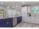 A modern kitchen with blue and white cabinets, stainless steel appliances, and luxury vinyl plank flooring at 1407 Noble Pl, Orlando, FL 32801