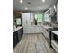 Modern kitchen with white cabinets, stainless steel appliances, stylish backsplash, and hardwood floors at 1407 Noble Pl, Orlando, FL 32801