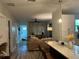 Open-concept kitchen and living room featuring hardwood floors, updated light fixtures, and neutral decor at 1407 Noble Pl, Orlando, FL 32801