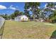 Spacious backyard featuring a deck, lush trees, and ample green space, perfect for outdoor activities at 1521 Nieuport Ln, Orlando, FL 32805