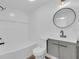 Inviting bathroom with updated vanity, round mirror, and a combined bathtub and shower with white tile surround at 1521 Nieuport Ln, Orlando, FL 32805