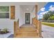 Charming front porch featuring a wooden shutter window accent and steps to the front door at 1521 Nieuport Ln, Orlando, FL 32805