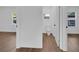 Open hallway connecting multiple rooms with consistent wood-look flooring and natural light from windows at 1521 Nieuport Ln, Orlando, FL 32805