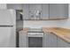 A modern kitchen featuring gray cabinets, butcher block countertops, and stainless steel appliances at 1521 Nieuport Ln, Orlando, FL 32805