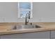 A bright and modern kitchen sink area with butcher block countertops and gray cabinets at 1521 Nieuport Ln, Orlando, FL 32805