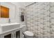 Modern bathroom with a vessel sink, stylish mirror, shelving, and a blue and brown patterned shower curtain at 1543 Reade Cir, St Cloud, FL 34772