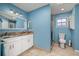 Stylish blue bathroom featuring a vanity with granite countertop, framed mirror, and walk-in shower at 1543 Reade Cir, St Cloud, FL 34772