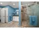 Stylish blue bathroom with a granite countertop vanity, framed mirror, and walk-in shower with glass doors at 1543 Reade Cir, St Cloud, FL 34772