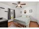 Cozy bedroom with a ceiling fan, wood-look floors, and a comfortable bed with floral patterned bedding at 1543 Reade Cir, St Cloud, FL 34772