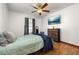 Bedroom featuring a ceiling fan, TV, wood-look floors, dresser, and a large window with gray curtains at 1543 Reade Cir, St Cloud, FL 34772