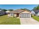 Charming single-story home featuring a well-maintained lawn, neutral paint, and attached two car garage at 1543 Reade Cir, St Cloud, FL 34772