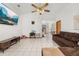 Spacious living room with tile floors, vaulted ceilings, fan, and ample natural light with an open view to the dining area at 1543 Reade Cir, St Cloud, FL 34772